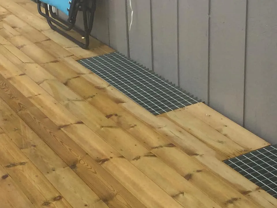 Gallerdurk i stål monterad över källarfönster i altandäck