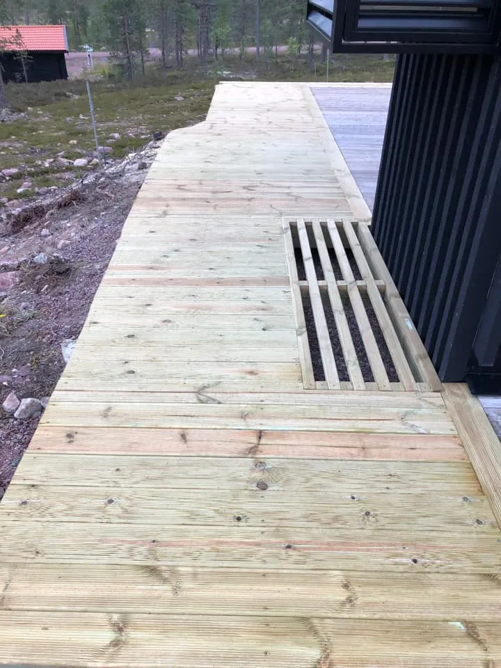 Trallbitar som galler över ljusgård i nybyggd altan