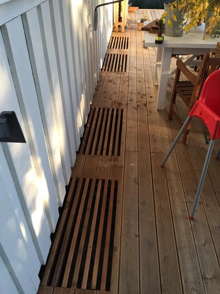 Trallbitar ställda på högkant över flera ljusgårdar längs husväggen