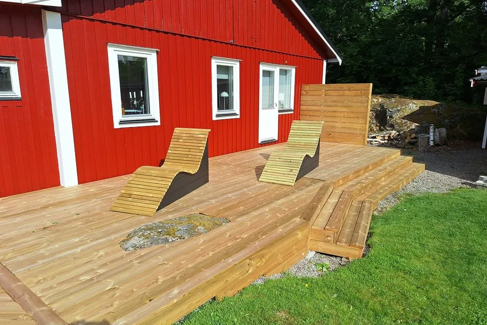 Två hemmabyggda solsängar i trä på en altan