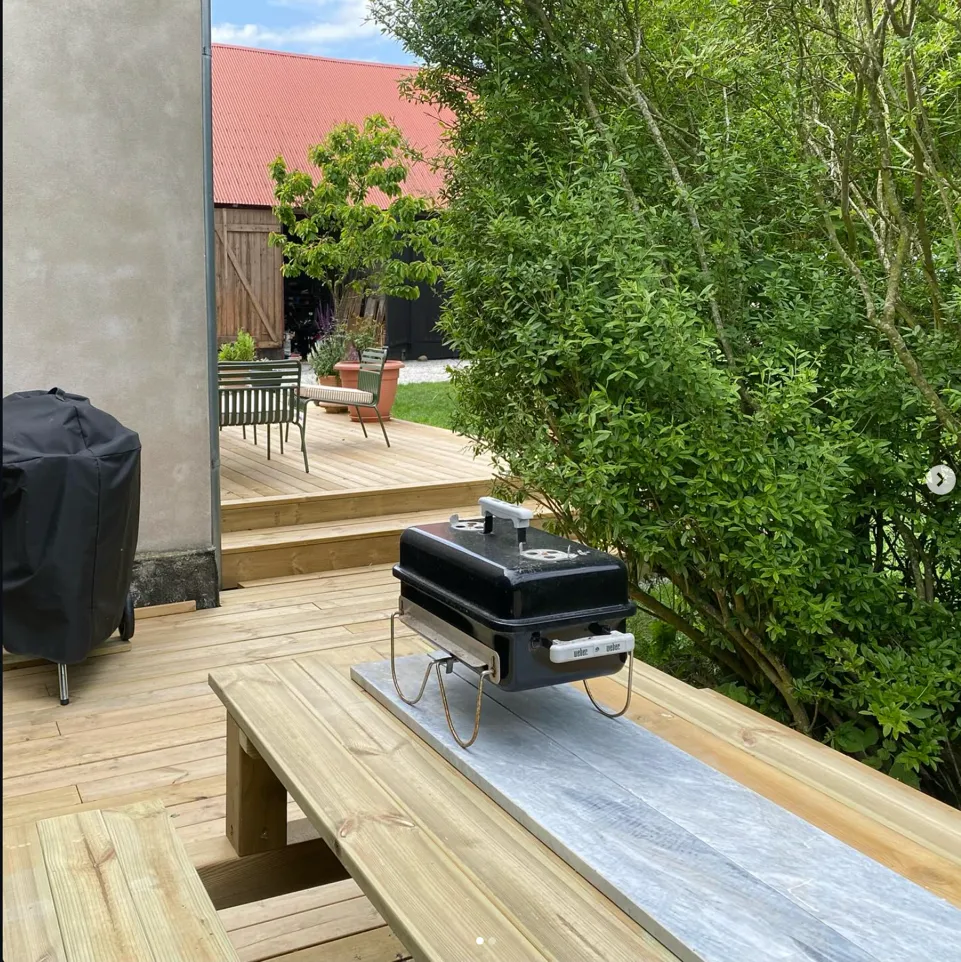 Grillhörnan med bänkar bakom huset