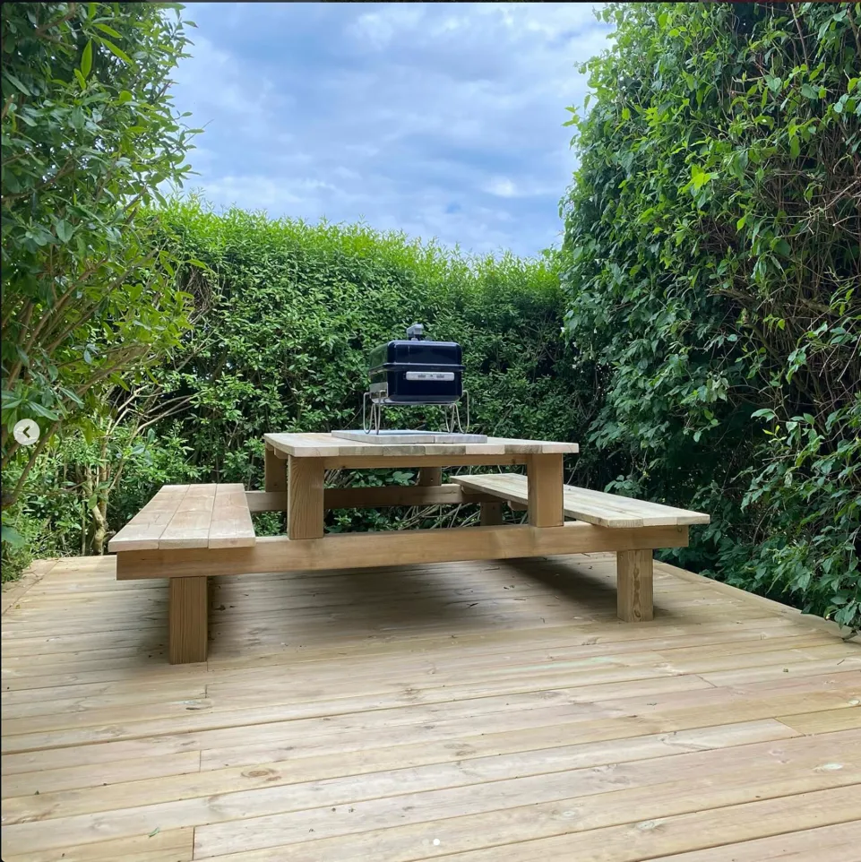 Stefans grillhörna med inbyggda bänkar omgiven av grönska