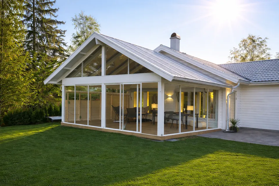 Inglasat uterum med sadeltak på villa i kvällssol