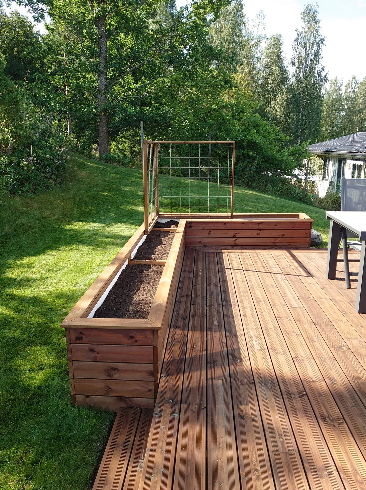 Planteringskärl på lägre altan med rillad trall.