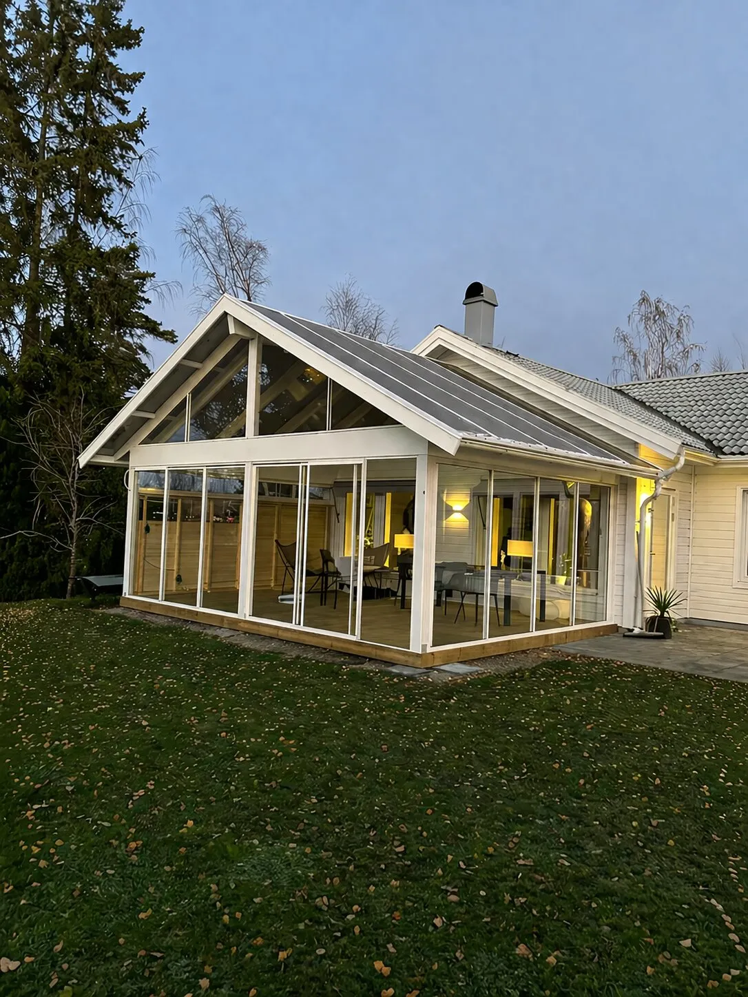 Vitt uterum med sadeltak sett utifrån i kvällsljus