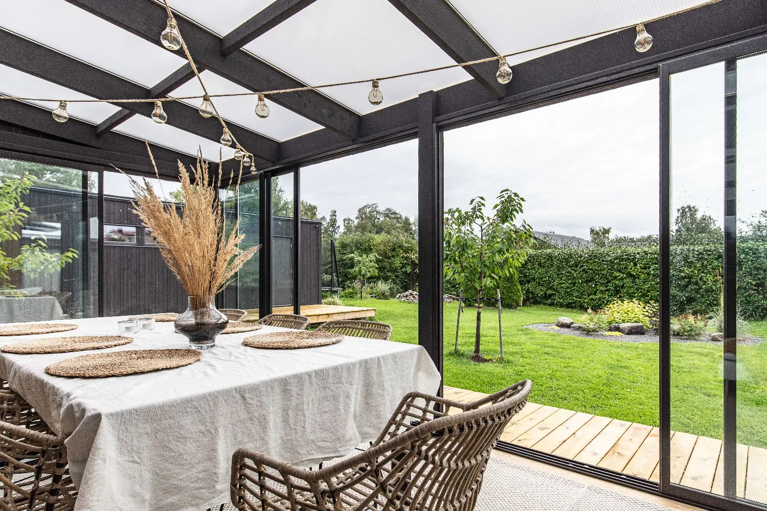 Svart uterum i vinkel med dukat bord och ljusslingor