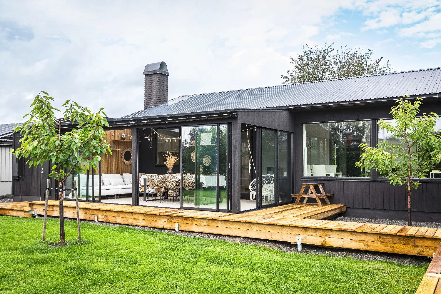 Närbild på elegant dukning med rottingstolar i svart uterum