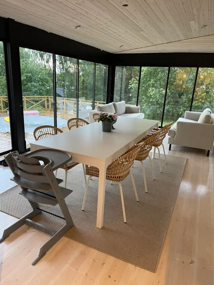 Ljus interiör med matbord och loungemöbler i modernt uterum