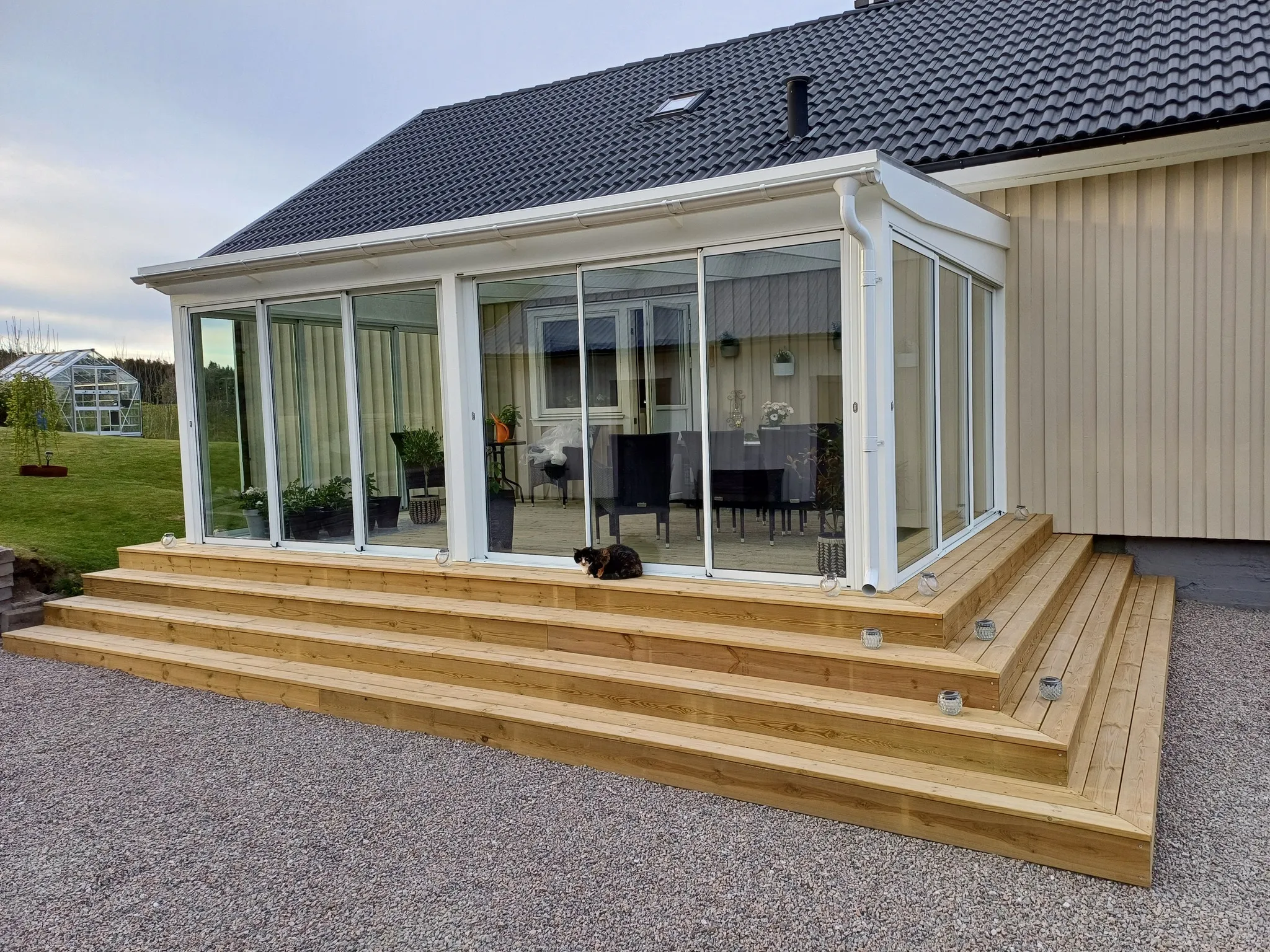 Uterum med vita ramar, trädäck och infälld trappbelysning